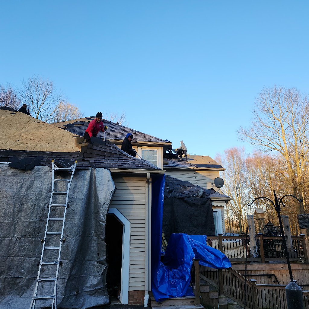 Before: Storm damage with blue tarps protecting the damaged roof